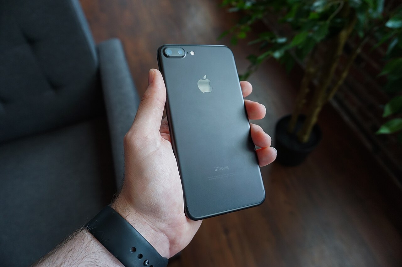 يد تحمل هاتفًا ذكيًا أسود.